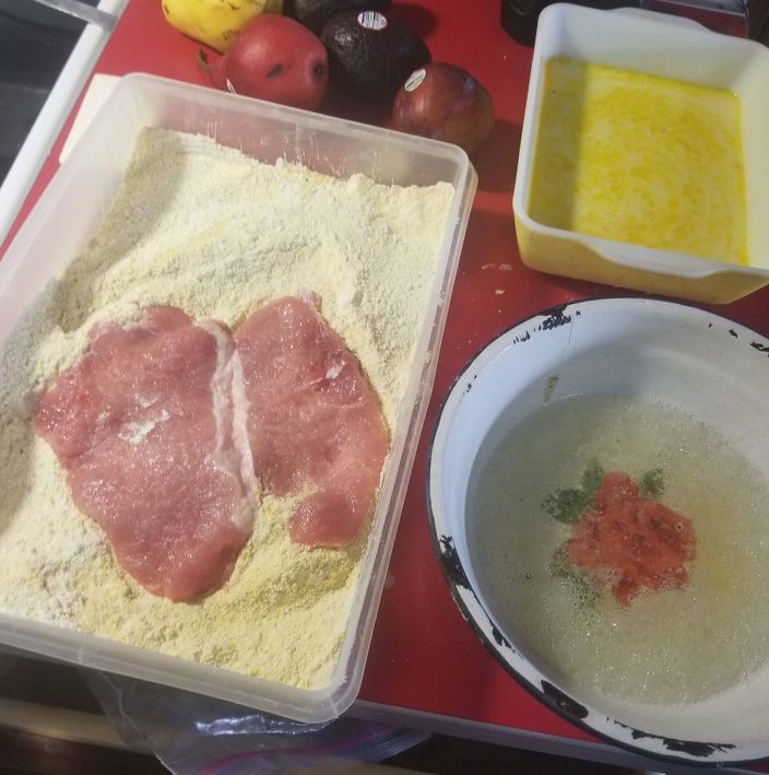 some food is laying out on a red table with white bowls and utensils