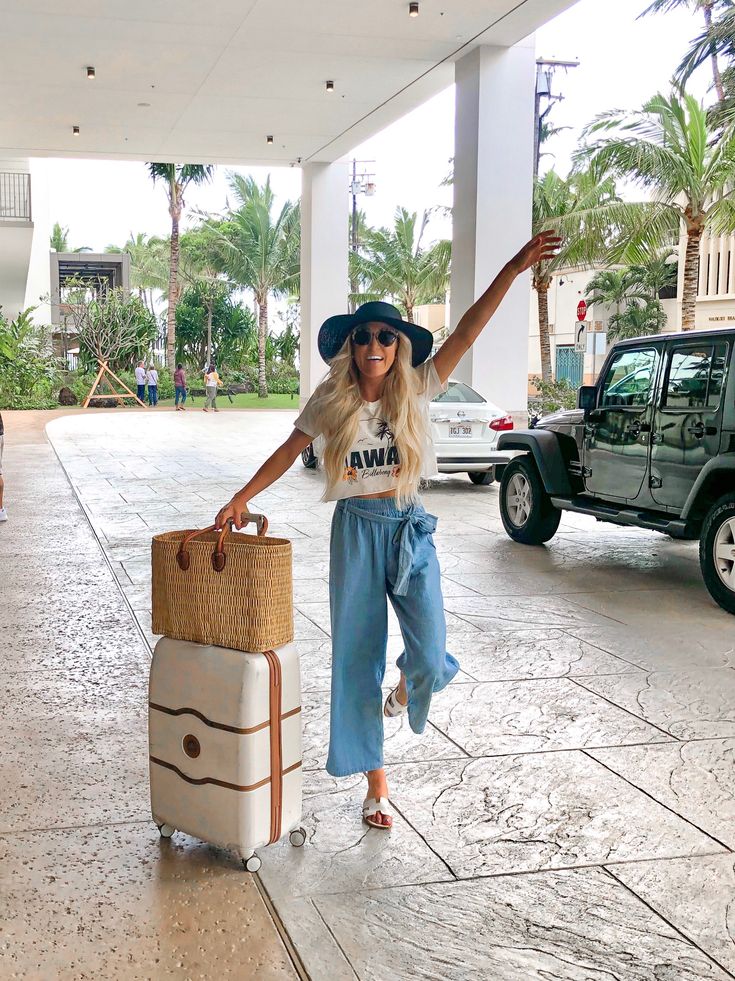 a woman is holding her luggage and smiling