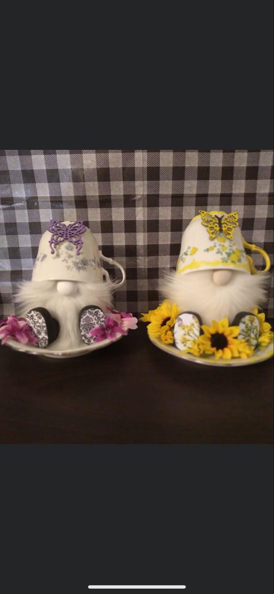 two plates with hats and flowers on them sitting on a table next to a black and white checkered wall