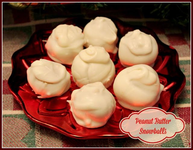 a red plate topped with white frosted donuts on top of a tablecloth