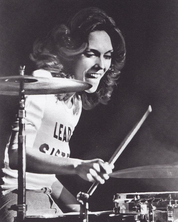 a woman is playing the drums on stage