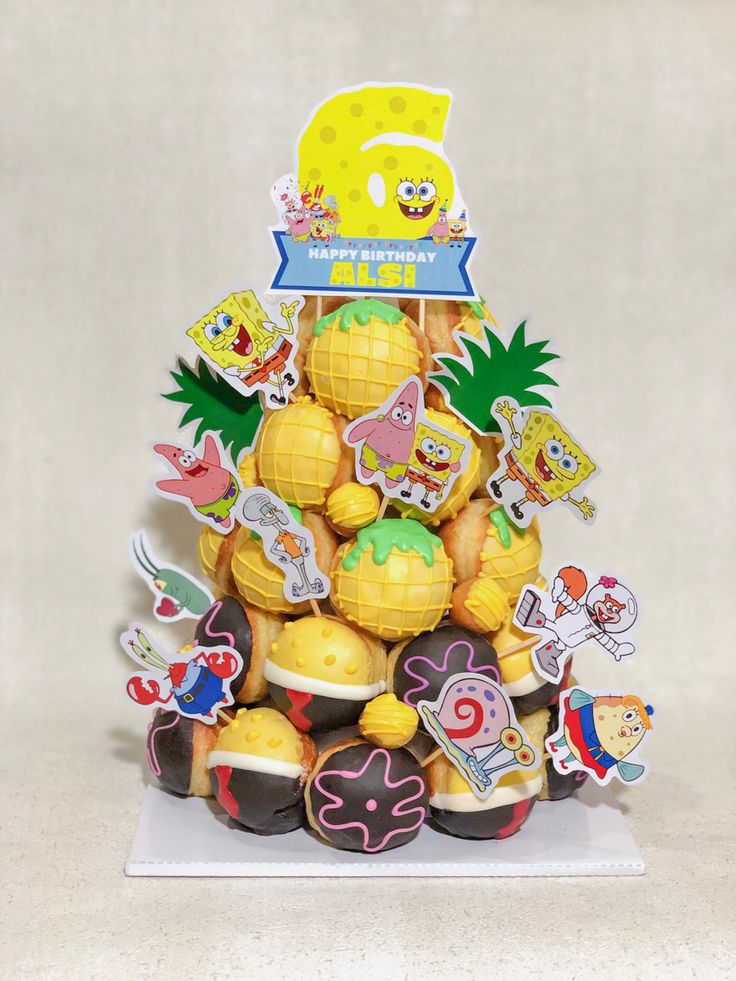 a pineapple shaped cake with lots of stickers on it