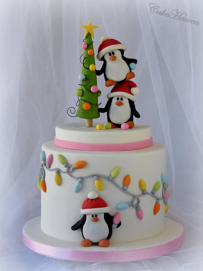 a cake decorated with penguins and christmas lights