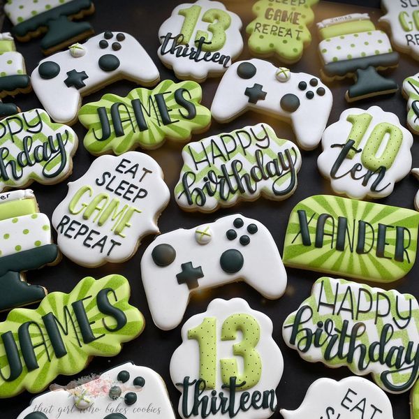 decorated cookies with video game controllers and happy 13th birthday written in green frosting on them