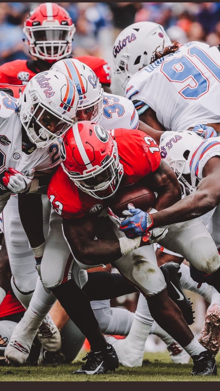 a group of football players running on top of each other