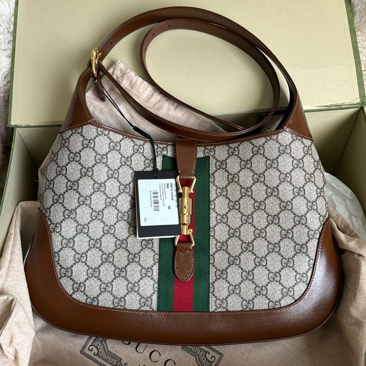 Style 636710 Huhhg 8565 The Reintroduction Of The Jackie Bag For Fall Winter 2020 Presents A New Take On A Historical Gucci Icon. Brought Back To The Forefront, The Recognizable Shape Is Presented In Gg Supreme Canvas And Enhanced With An Additional, Detachable Shoulder Strap. Attached To The Bag With A Buckle Closure, The Second Strap Adds A Contemporary Feel To The Archival Style, Providing New Ways To Wearfrom Top Handle, Shoulder To Cross Body. Pieces With Versatile Ways To Wear And Style Em Designer Tan Shoulder Bag, Pre-owned Rectangular Gucci Shoulder Bag, Pre-owned Gucci Leather Bag, Designer Formal Pre-owned Shoulder Bag, Pre-owned Classic Gucci Bags, Pre-owned Luxury Leather Shoulder Bag, Luxury Gucci Bag With Horsebit Detail, Designer Pre-owned Rectangular Shoulder Bag, Formal Monogram Canvas Bag With Horsebit Detail