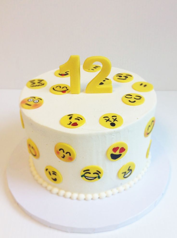 a white cake topped with lots of smiley faces on it's sides and the number twenty two