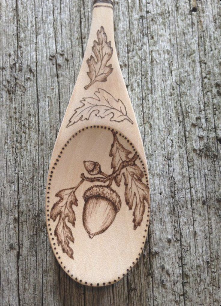 a wooden spoon with an acorn design on it