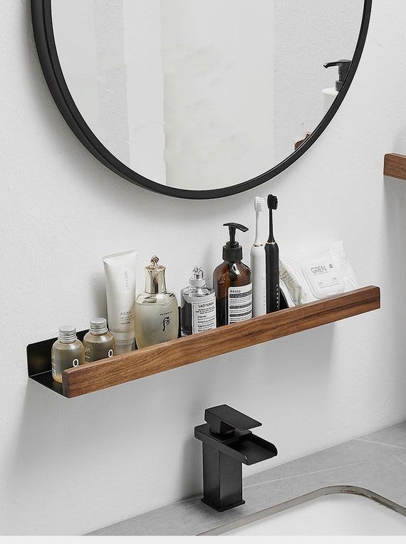 a bathroom sink with soap, toothbrushes and lotion on the shelf next to it