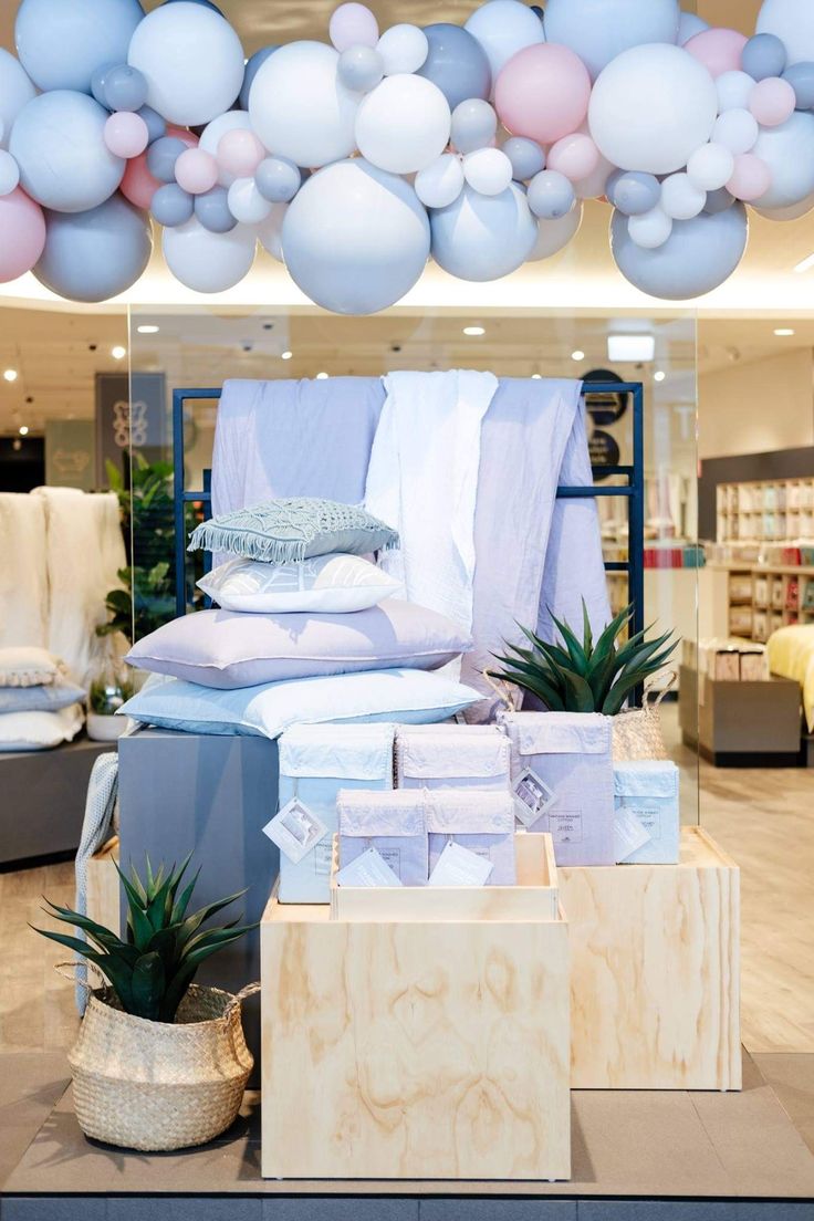 a display in a store filled with lots of pillows and blankets on top of boxes