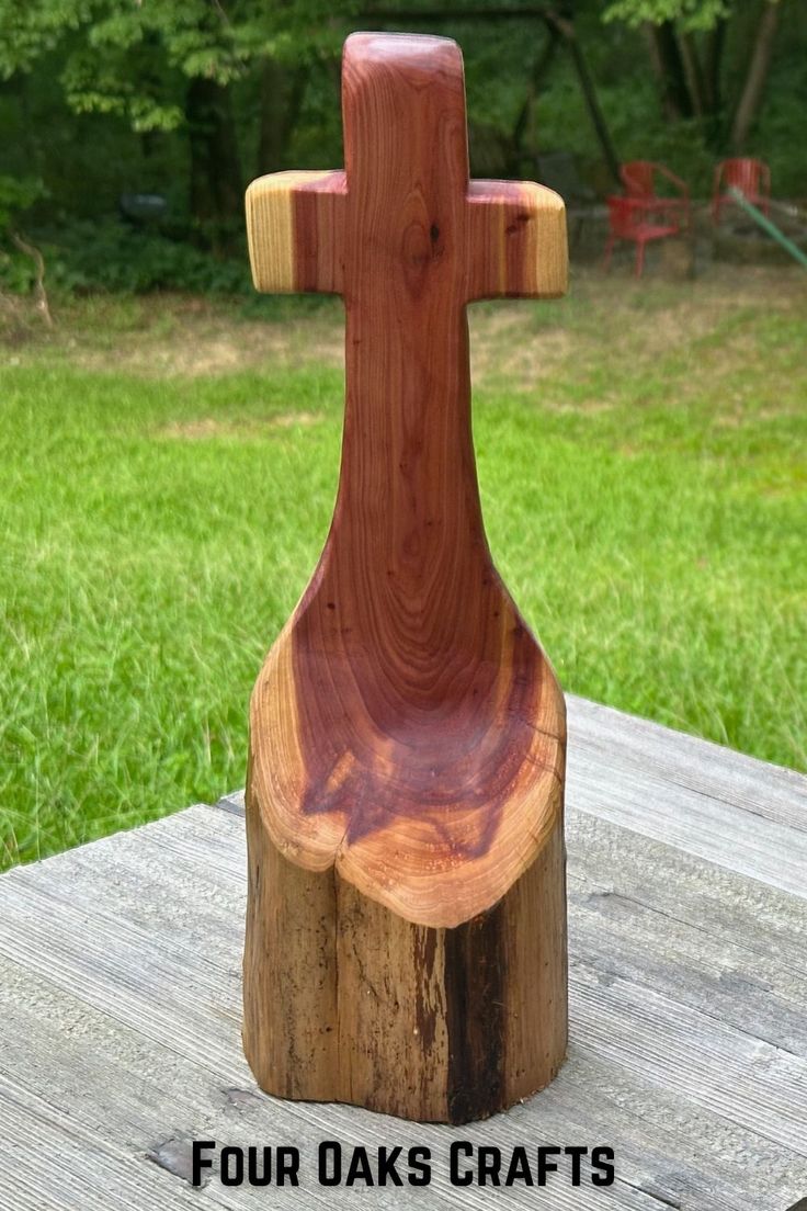 a wooden cross sitting on top of a piece of wood with the words four oaks crafts written below it