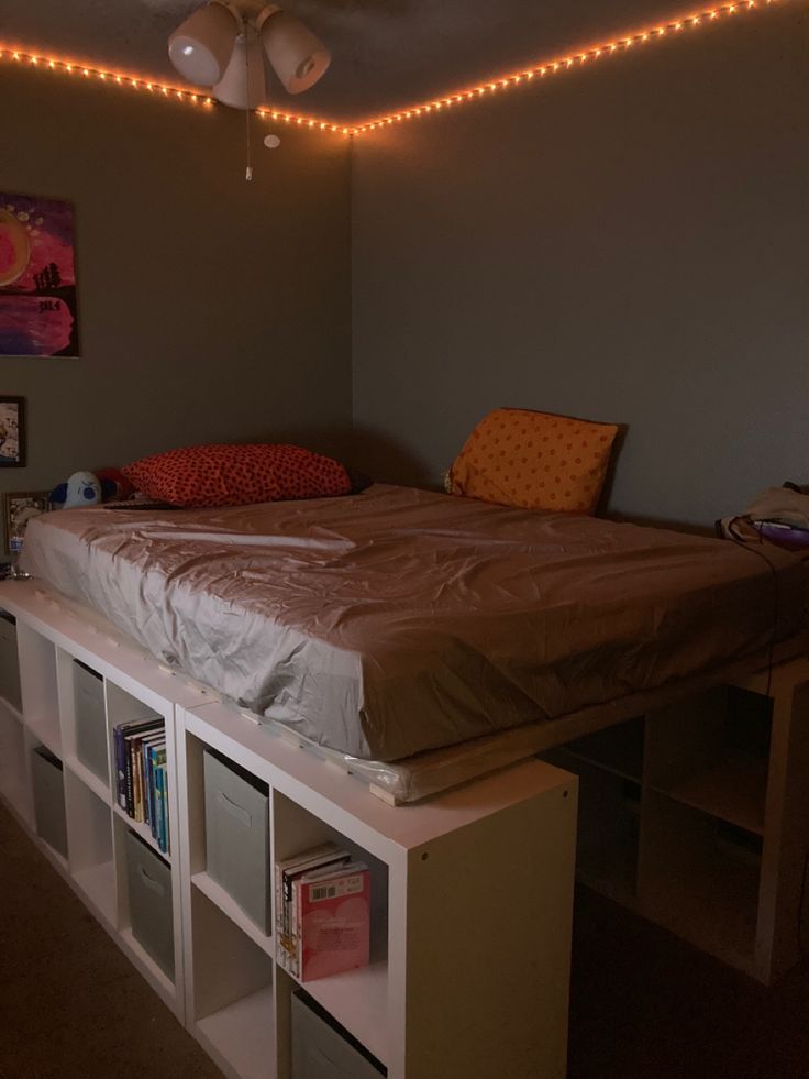 a bed sitting on top of a white shelf under a ceiling fan