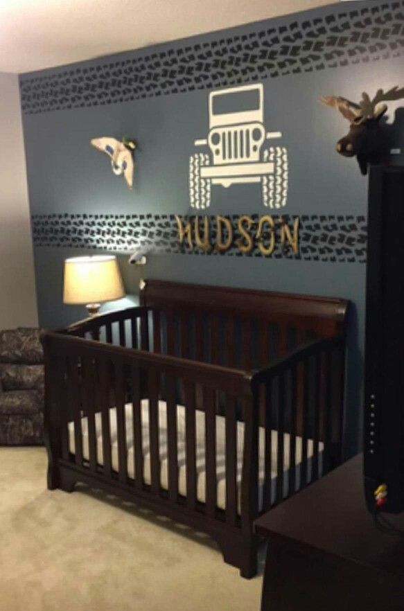 a baby's room decorated in blue and brown with jeep decals on the wall