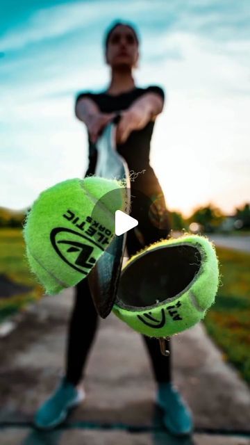 a person holding two tennis balls in their hands