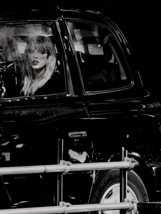 a black and white photo of a woman in a car