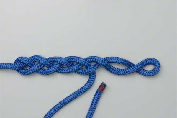 a blue rope that has been tied to the ground with a red hook on it