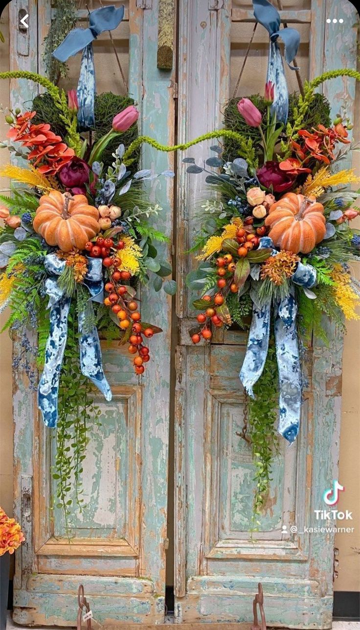 two doors decorated with fall flowers and pumpkins are shown in front of an old door