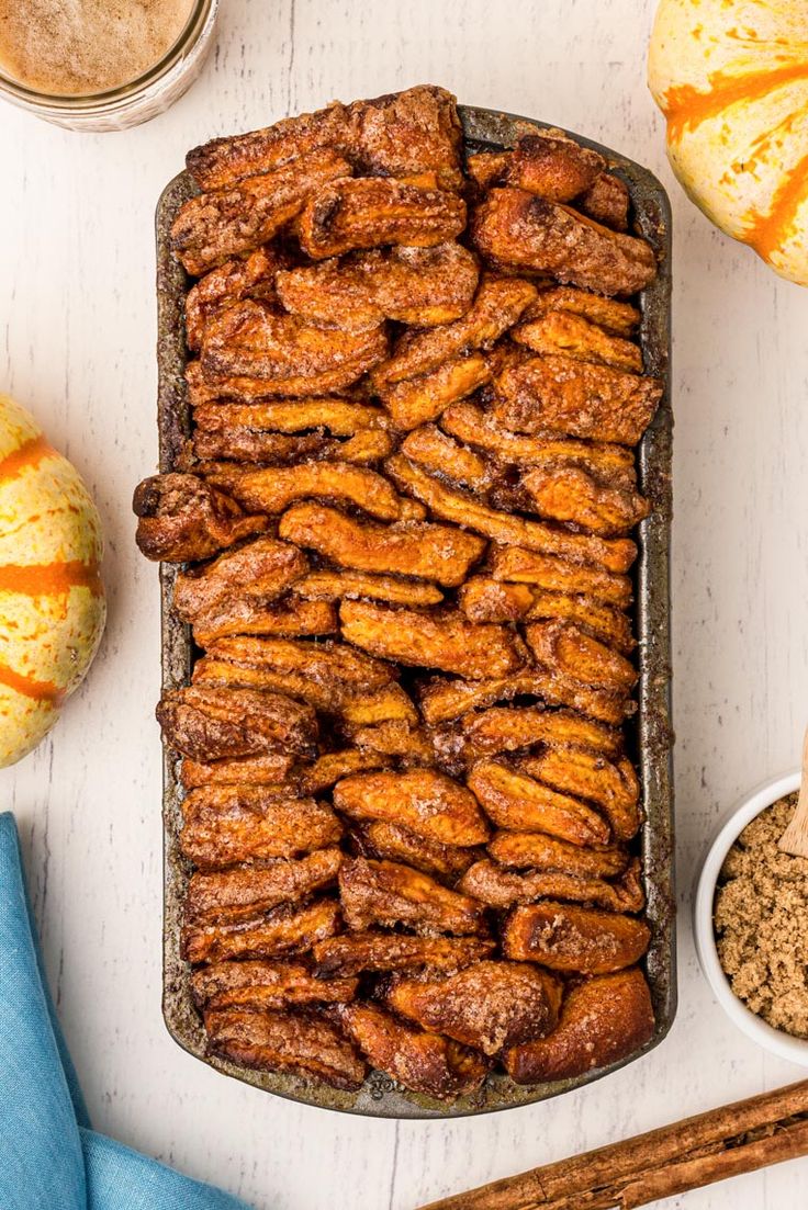 an overhead view of baked goods on a table with oranges and cinnamon in the background