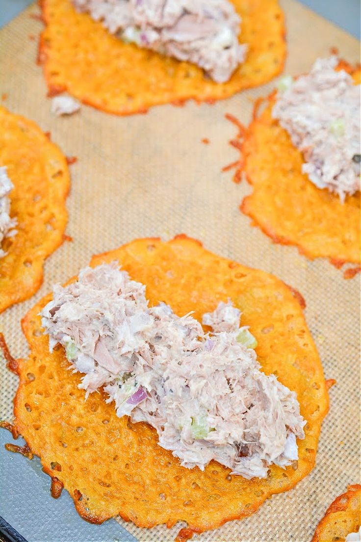 crackers with crab salad on them sitting on a baking sheet