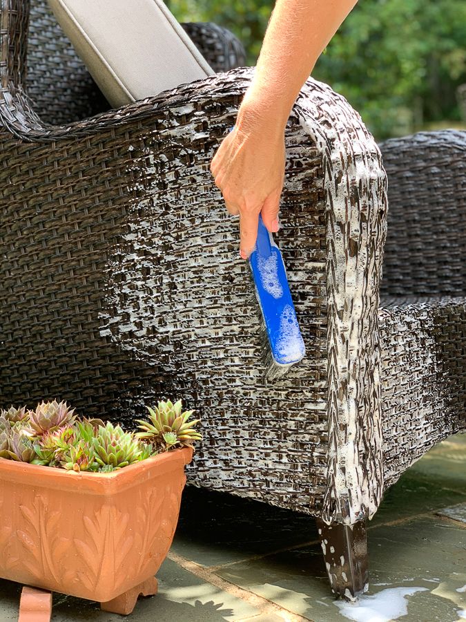 a person is using a blue toothbrush to clean a chair with succulents