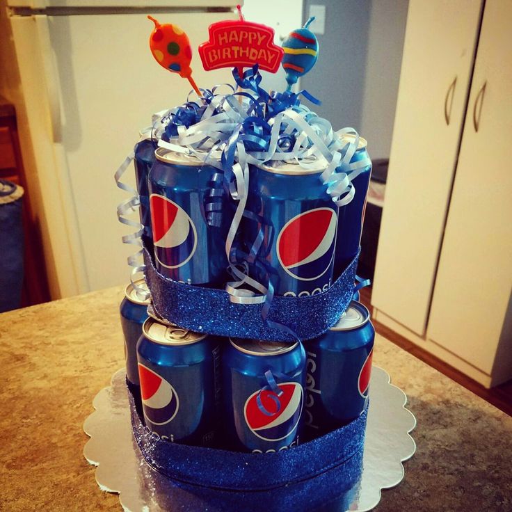 a birthday cake made to look like soda cans with blue ribbon and decorations on top