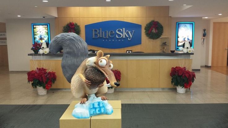 a statue of a squirrel holding an iceberg in front of a blue sky sign