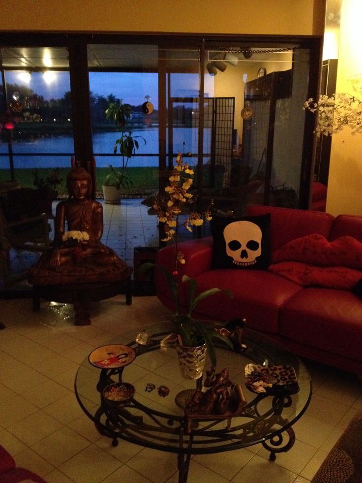 a living room filled with red couches and a glass top table in front of a large window