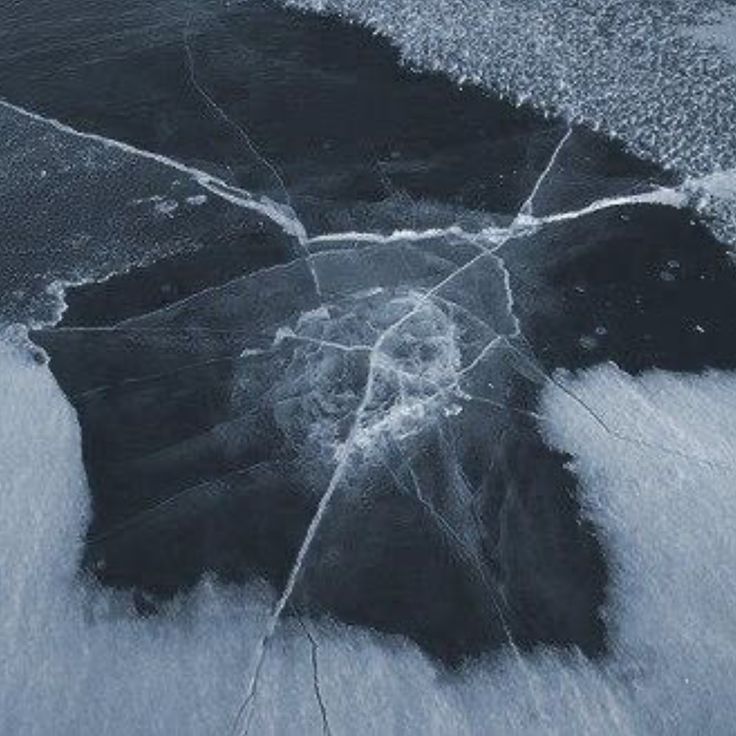 an abstract photograph of water and ice on the ground, with small bubbles in it