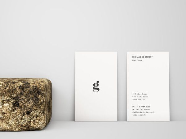 a rock and business card sitting on top of each other in front of a white background