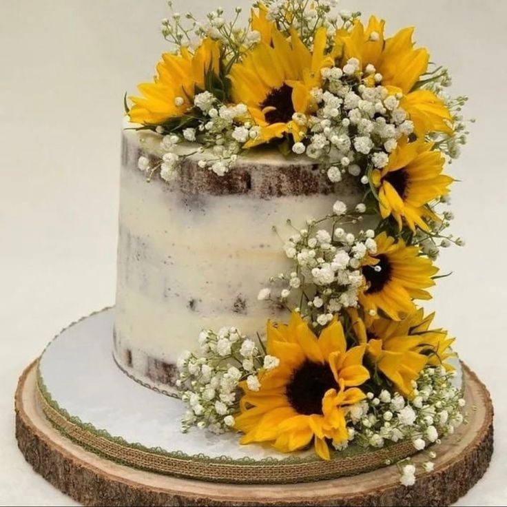 a cake with sunflowers and baby's breath on top