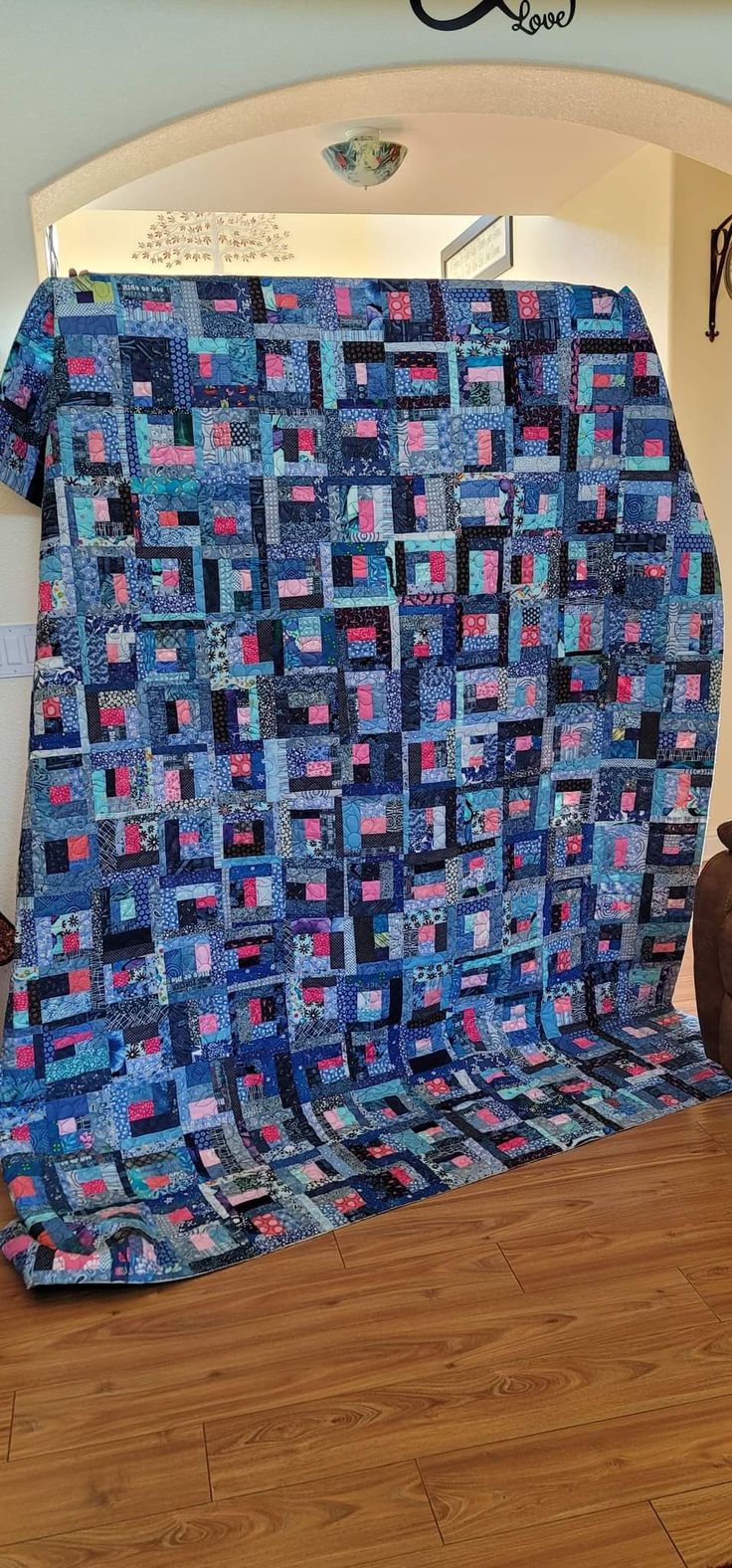 a large blue quilt sitting on top of a hard wood floor