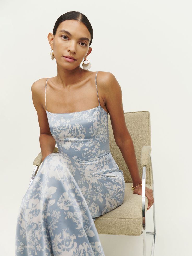 a woman in a blue dress sitting on a chair