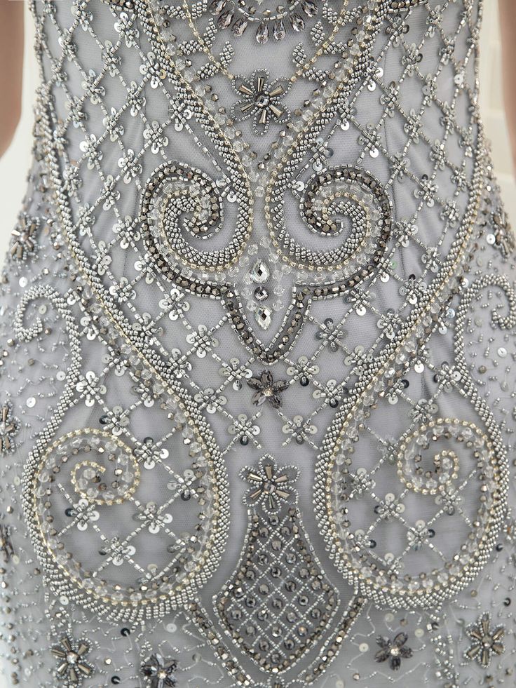 the back of a woman's dress with beading and sequins on it