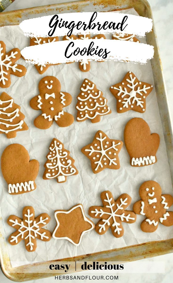 gingerbread cookies on a baking sheet with icing and snowflakes in the background