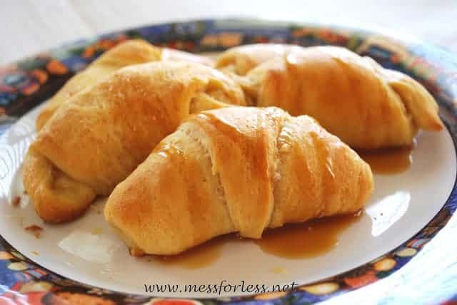 three croissants on a plate with caramel sauce