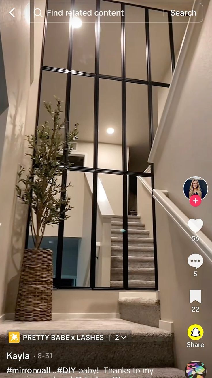 an image of a house with stairs and mirrors on the wall, as well as a potted plant