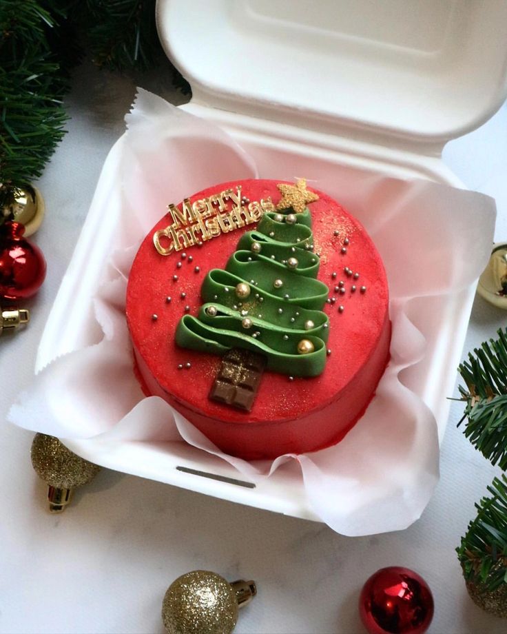 a decorated christmas cake in a white box