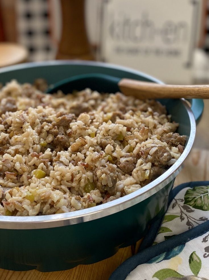 a green bowl filled with rice on top of a wooden table