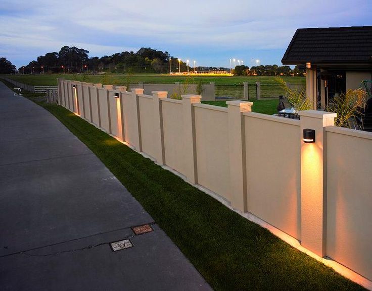 a long white fence with lights on it