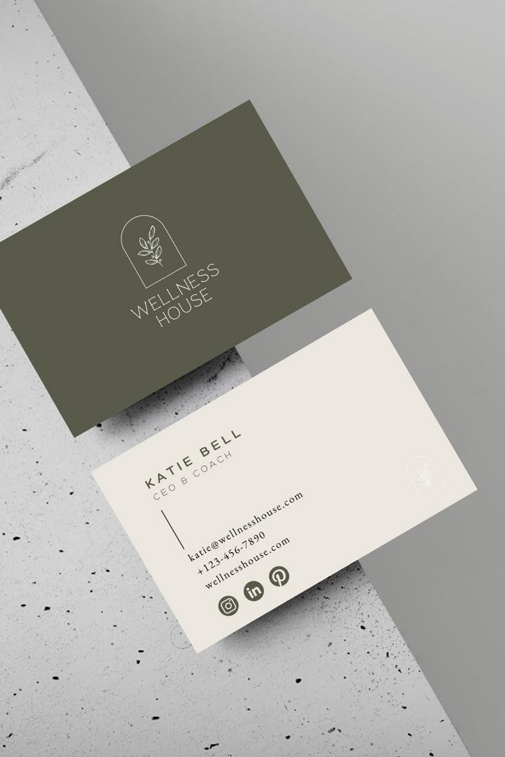 two business cards sitting on top of each other in front of a white and green background