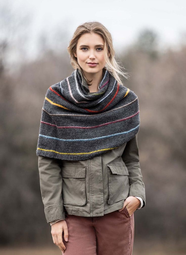 a woman wearing a gray jacket and striped shawl