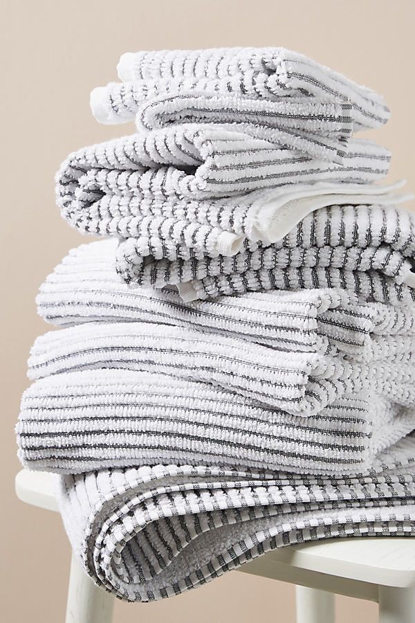 stack of folded towels sitting on top of a white chair