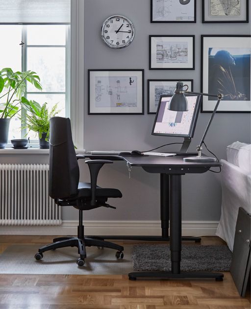 a desk with a laptop computer sitting on top of it in front of a window