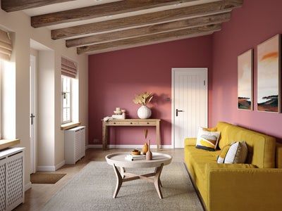 a living room with pink walls and yellow furniture