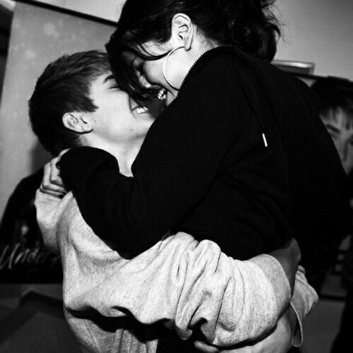 two people are hugging each other in black and white