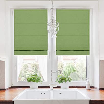 a white sink sitting under a window next to two windows with roman shades on them