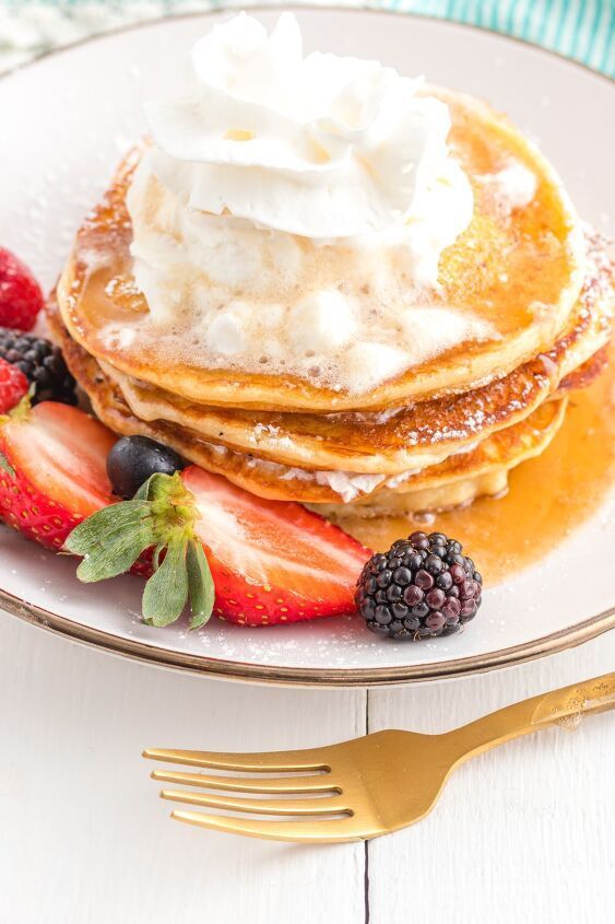 pancakes with whipped cream and berries on a plate