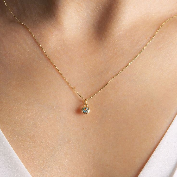 "Dainty 14K solid gold sky blue topaz pendant necklace. The bezel of the stone is designed with small windows under the bezel to get more light which shows the sparkle and color of the stone better. **Details** ✪ Pendant Material: 14K Solid Gold Stone: Sky Blue Topaz Total CTW: 0,15ct Cut: Round Approximate Dimensions: Stone: 3mm Bezel: 4,75mm (exluding jump ring) Charm: 9mm (including jump ring) ✪ Chain: Material: 14K Solid Gold Width: 0,50mm Length: 18 inches ( approx. 46cm ) Closure: Spring R Gold Dainty Necklace Celestite, Blue Topaz Birthstone Necklace For Anniversary, Gold Aquamarine Jewelry With Bezel Setting, Gold Aquamarine Birthstone Necklace, Anniversary Blue Topaz Birthstone Necklace, Fine Jewelry Topaz With Bezel Setting, Aquamarine Birthstone Necklace For Anniversary, Fine Jewelry Blue Topaz Birthstone Necklace For Gifts, Blue Topaz Bezel Setting Jewelry Gift