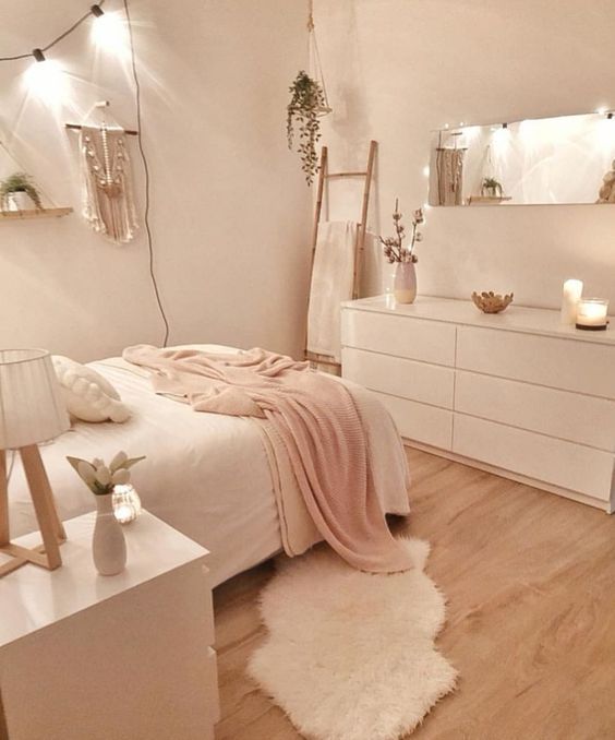 a bedroom with pink walls and white furniture, including a large mirror on the wall