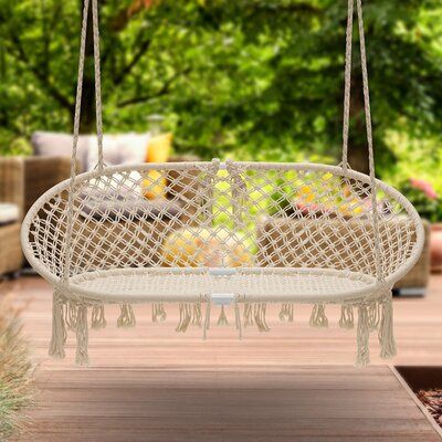 a white hanging chair on a wooden deck